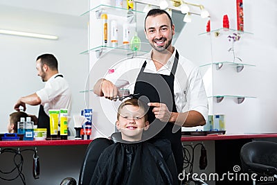 Smiling boy getting hairstyle of man hairdresser Stock Photo