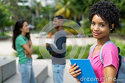 Smiling brazilian female student with group of friends Stock Photo