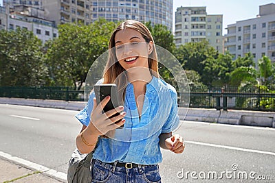Smiling Brazilian girl using smartphone on Minhocao highway on sunday, Sao Paulo, Brazil Stock Photo