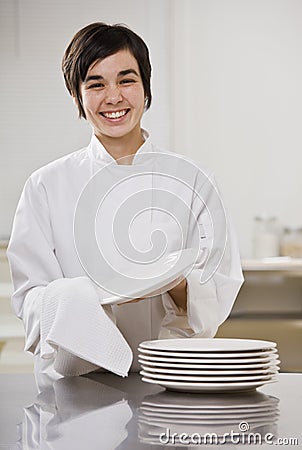Smiling brunette drying dishes. Stock Photo