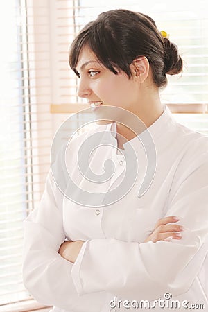 Smiling brunette in smock looking to window Stock Photo