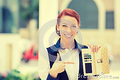 Smiling business woman pointing at many credit cards in her wallet Stock Photo