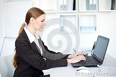 Smiling business woman working on a laptop at offi Stock Photo