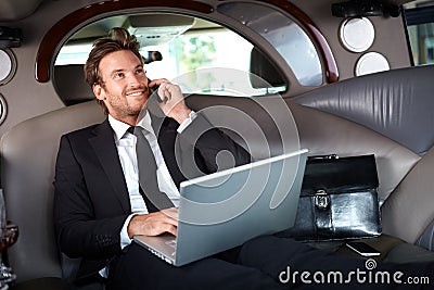 Smiling businessman in luxury car working Stock Photo