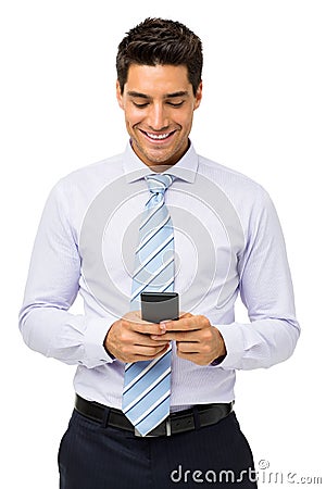 Smiling Businessman Text Messaging On Smart Phone Stock Photo