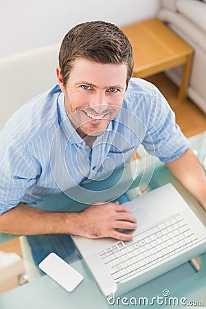 Smiling businessman using his laptop at desk Stock Photo