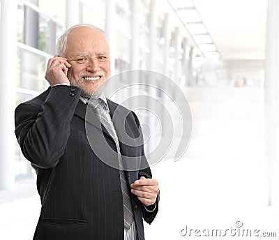 Smiling businessman using mobile phone Stock Photo