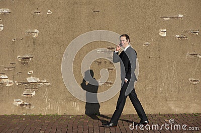 Smiling businessman walking and talking on mobile phone Stock Photo