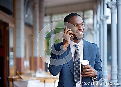 Smiling businessman walking and talking on mobile phone Stock Photo