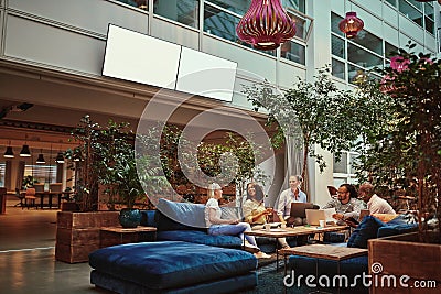 Smiling businesspeople relaxing in the lounge area of an office Stock Photo