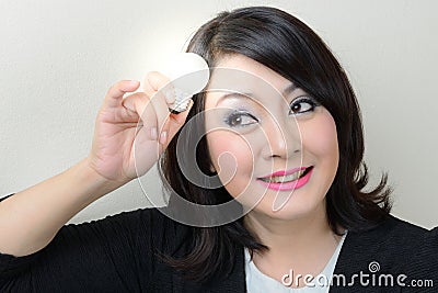 Smiling businesswoman having an idea with bright light bulb Stock Photo