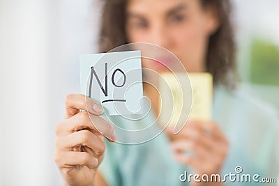 Smiling businesswoman holding yes and no sticks Stock Photo