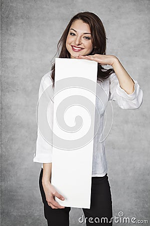 Smiling businesswoman holds a place for your advertisement Stock Photo