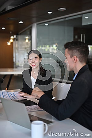 Businesswoman negotiating about business project with her colleague at office. Stock Photo