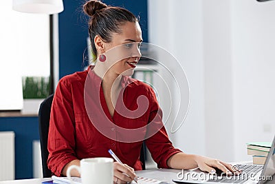 Smiling businesswoman reading data from laptop screen Stock Photo