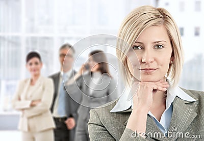 Smiling businesswoman with team Stock Photo