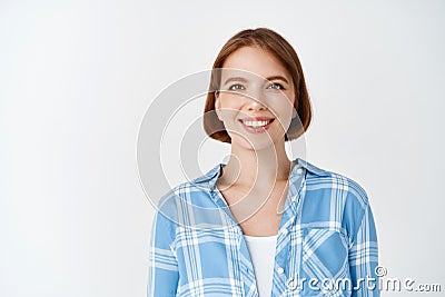 Smiling candid woman in casual clothes looking happy. Young girl with short hair and light make-up standing on white Stock Photo