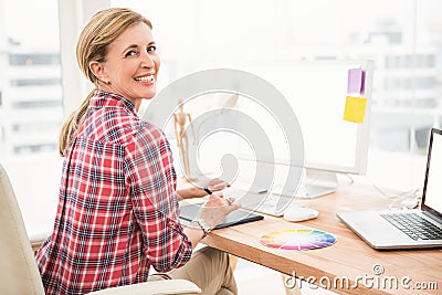 Smiling casual designer using computer and digitizer Stock Photo