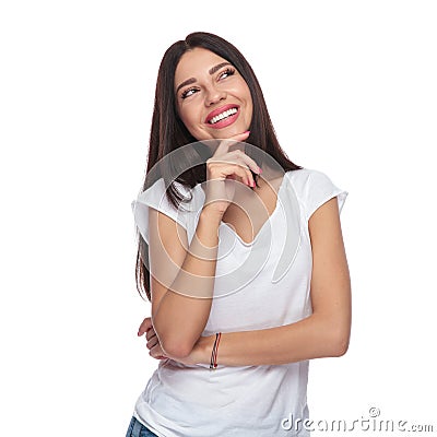 Smiling casual woman looking up to side while thinking Stock Photo