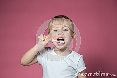 Smiling caucasian little boy cleaning his teeth with manual children toothbrush Stock Photo