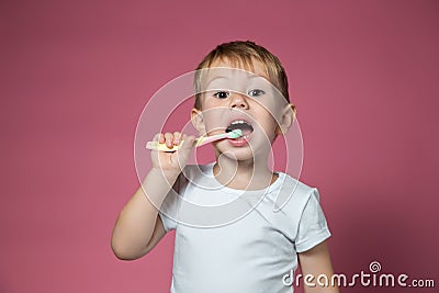 Smiling caucasian little boy cleaning his teeth with manual children toothbrush Stock Photo