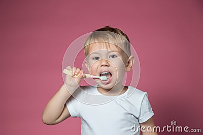 Smiling caucasian little boy cleaning his teeth with manual children toothbrush Stock Photo