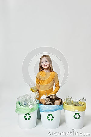 Smiling girl with plastic bottle sorting garbage Stock Photo