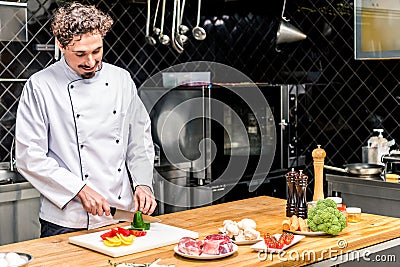 smiling chef cutting colored bell Stock Photo