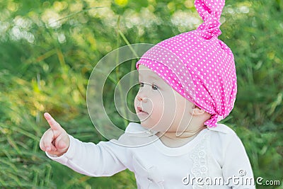 Smiling child in the grass. Hat in polka dots. Green grass. Smiling child. Stock Photo