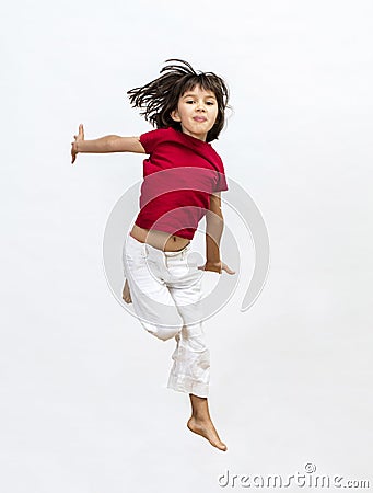 Smiling child jumping expressing success, dynamic childhood and open mindedness Stock Photo