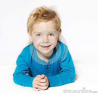 Smiling child lying down, looking at camera Stock Photo