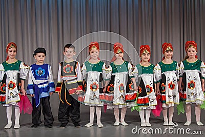 The smiling children in folk costume performs on stage Editorial Stock Photo