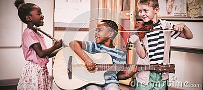 Children playing musical instruments in classroom Stock Photo