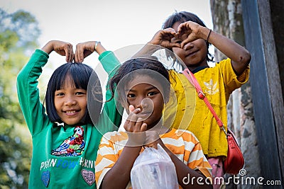 Smiling children standing side by side showing heart gestures Editorial Stock Photo