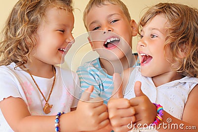 Smiling children three together shows ok gesture Stock Photo