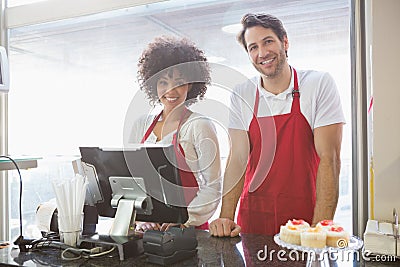 Smiling co-workers posing together behind the counter Stock Photo