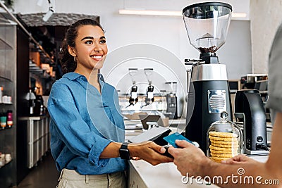 Smiling coffee shop owner holding POS terminal Stock Photo