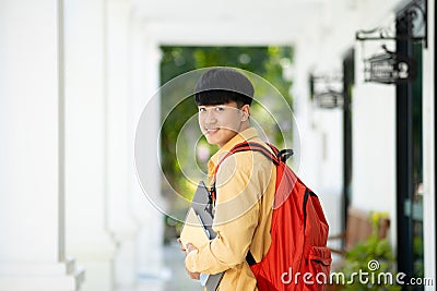 Smiling College Student Holding Books in School Corridor Stock Photo