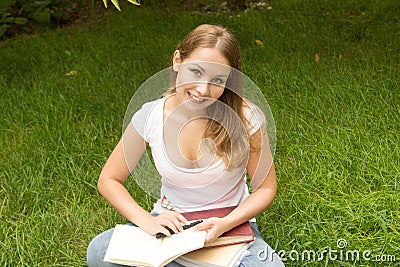 Smiling college student reading a book Stock Photo