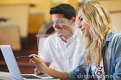 Smiling college students using laptop Stock Photo