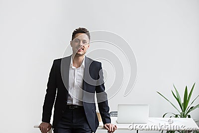 Smiling company CEO posing near office desk Stock Photo