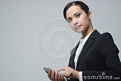 Smiling confident businesswoman using touch screen mobile phone Stock Photo