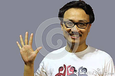 A smiling and confident manipuri north east indian man with spectacles showing the sign of five with fingers Stock Photo