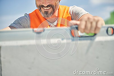 Smiling constructor worker using a spirit level Stock Photo