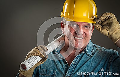 Friendly Contractor in Hard Hat Holding Floor Plans Stock Photo