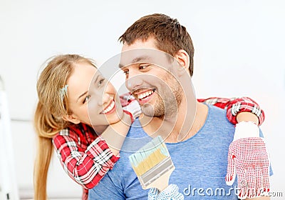 Smiling couple covered with paint with paint brush Stock Photo
