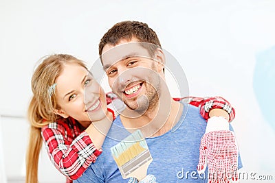 Smiling couple covered with paint with paint brush Stock Photo