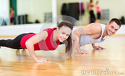 Smiling couple doing push-ups in the gym Stock Photo