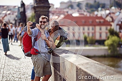 Smiling couple in love walking on a street of Prague city and make selfie Stock Photo