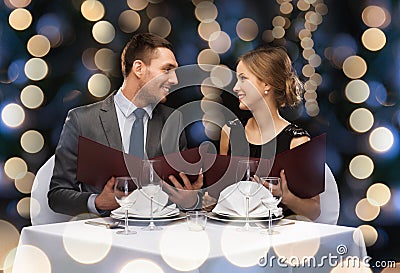 Smiling couple with menus at restaurant Stock Photo